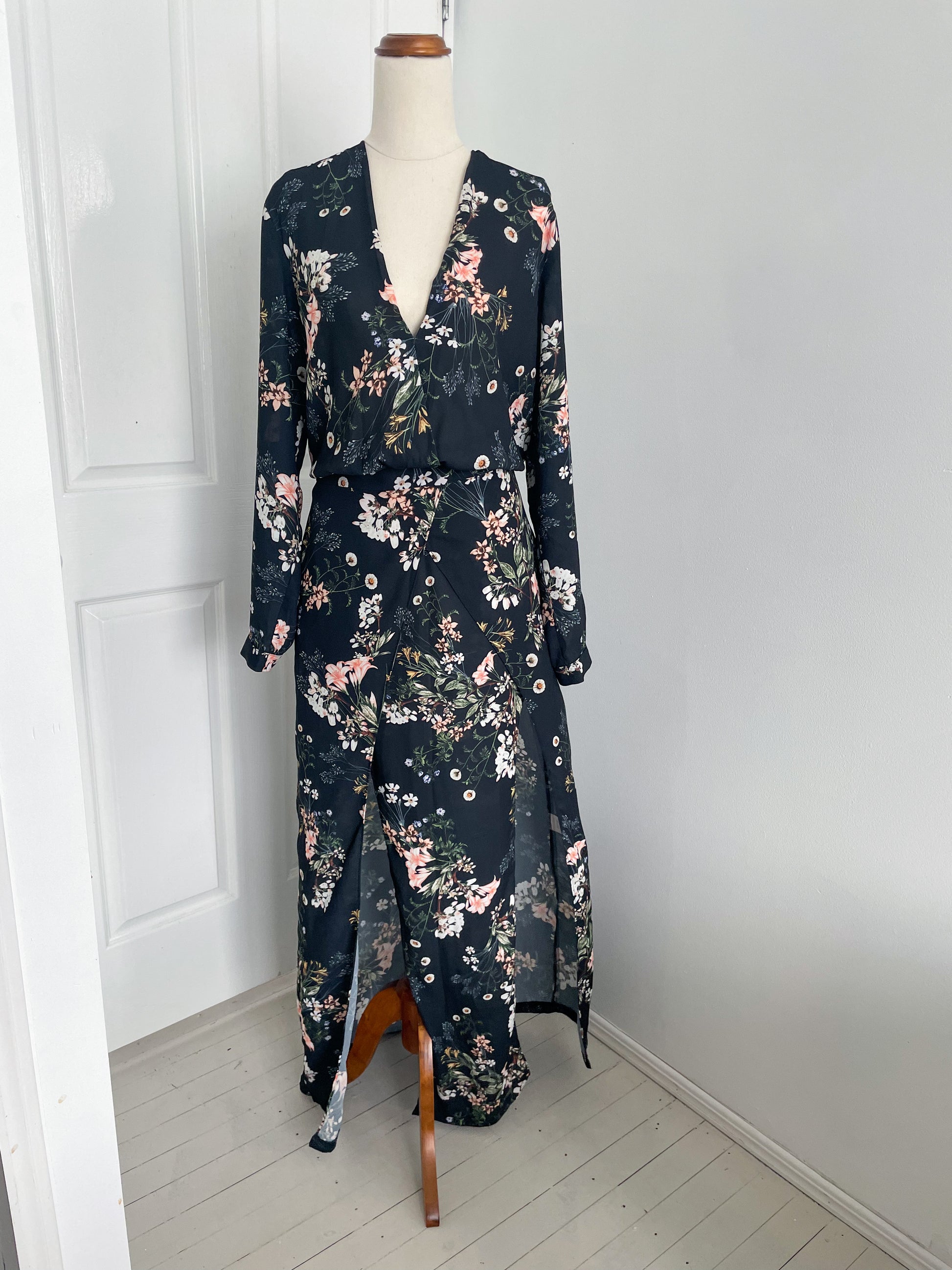 Sheike Midnight blooms dress. A long sleeve dress with plunging neck line and two front slits. the colour of the dress is pastel floral pattern on a dark fabric