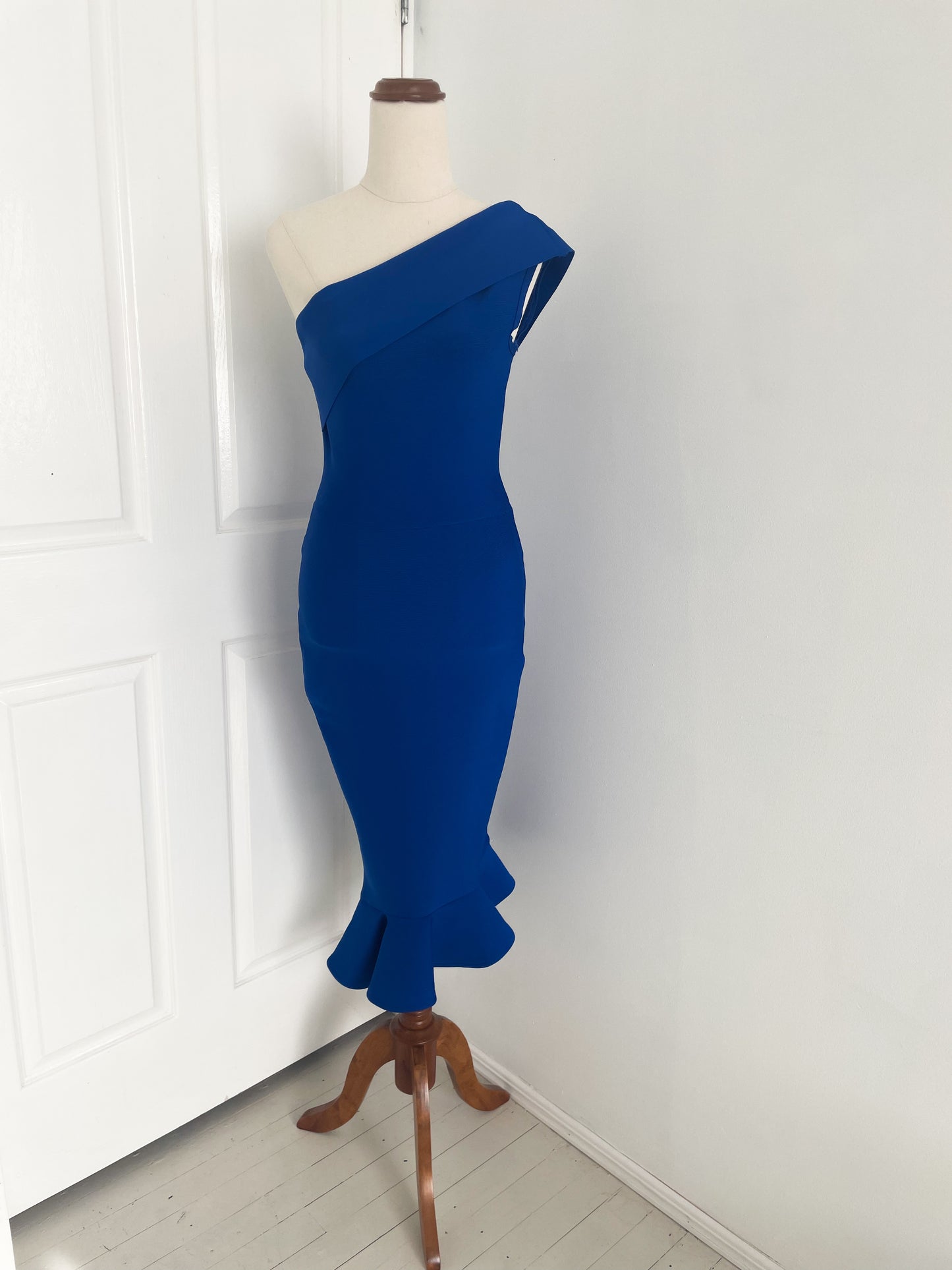 of royal blue cocktail dress with a ruffle hem and one shoulder detail on a mannequin