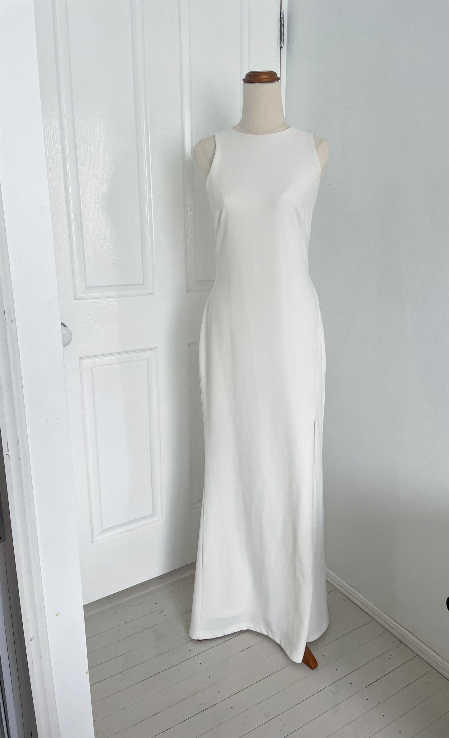 Cruz Bridal Gown by Pasduchas. A white high neck gown, maxi floor length with an open back and halter neck closure