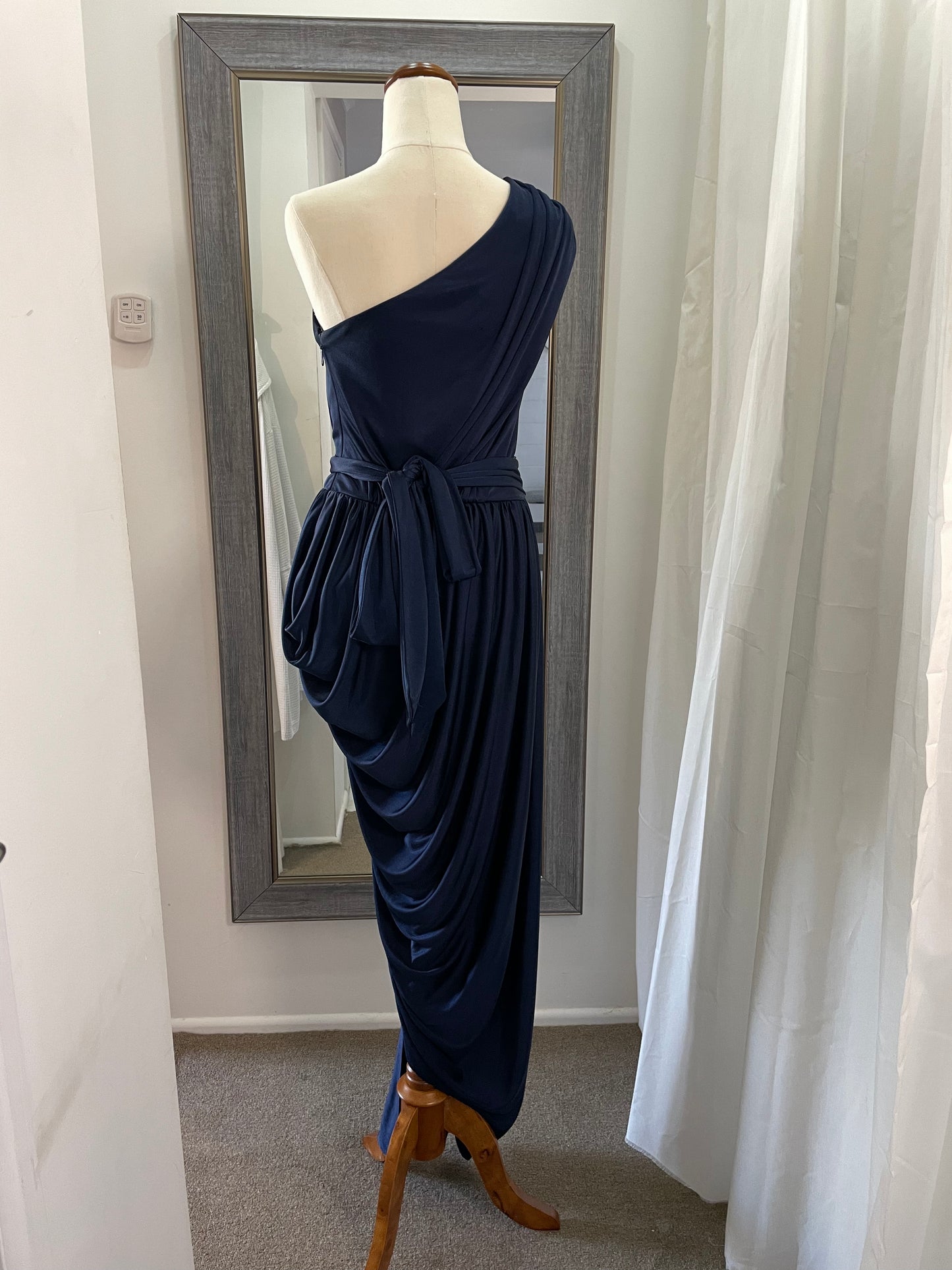Sheike navy blue cocktail dress. one shoulder, draping material with leg split and waist tie back view