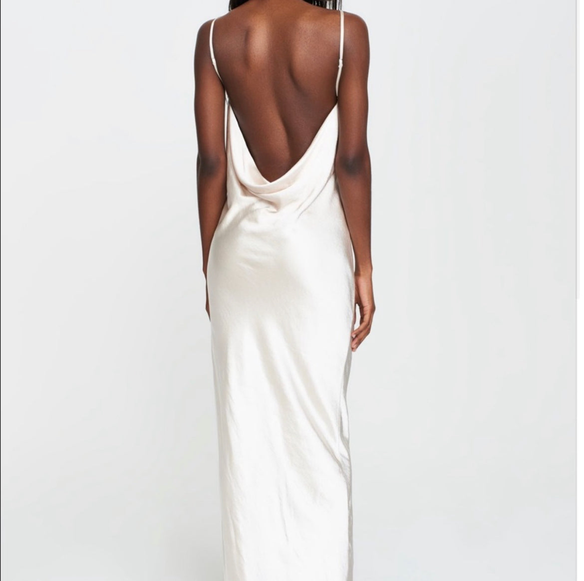 woman wearing satin white formal gown with thin spaghetti straps a draped cowl back